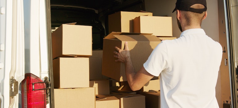 A man filling a van with boxes, preparing for moving during the holidays