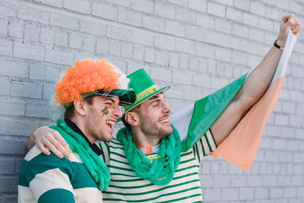 Two friends dressed in Irish outfits smiling in the street
