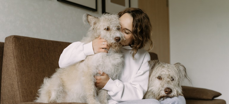 A woman holding her two dogs