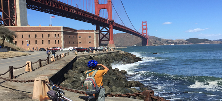 Person taking a picture of the Golden Gate Bridge in San Francisco, one of the best biking cities in the US