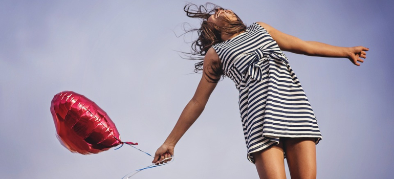 Smiling girl with a helium baloon.