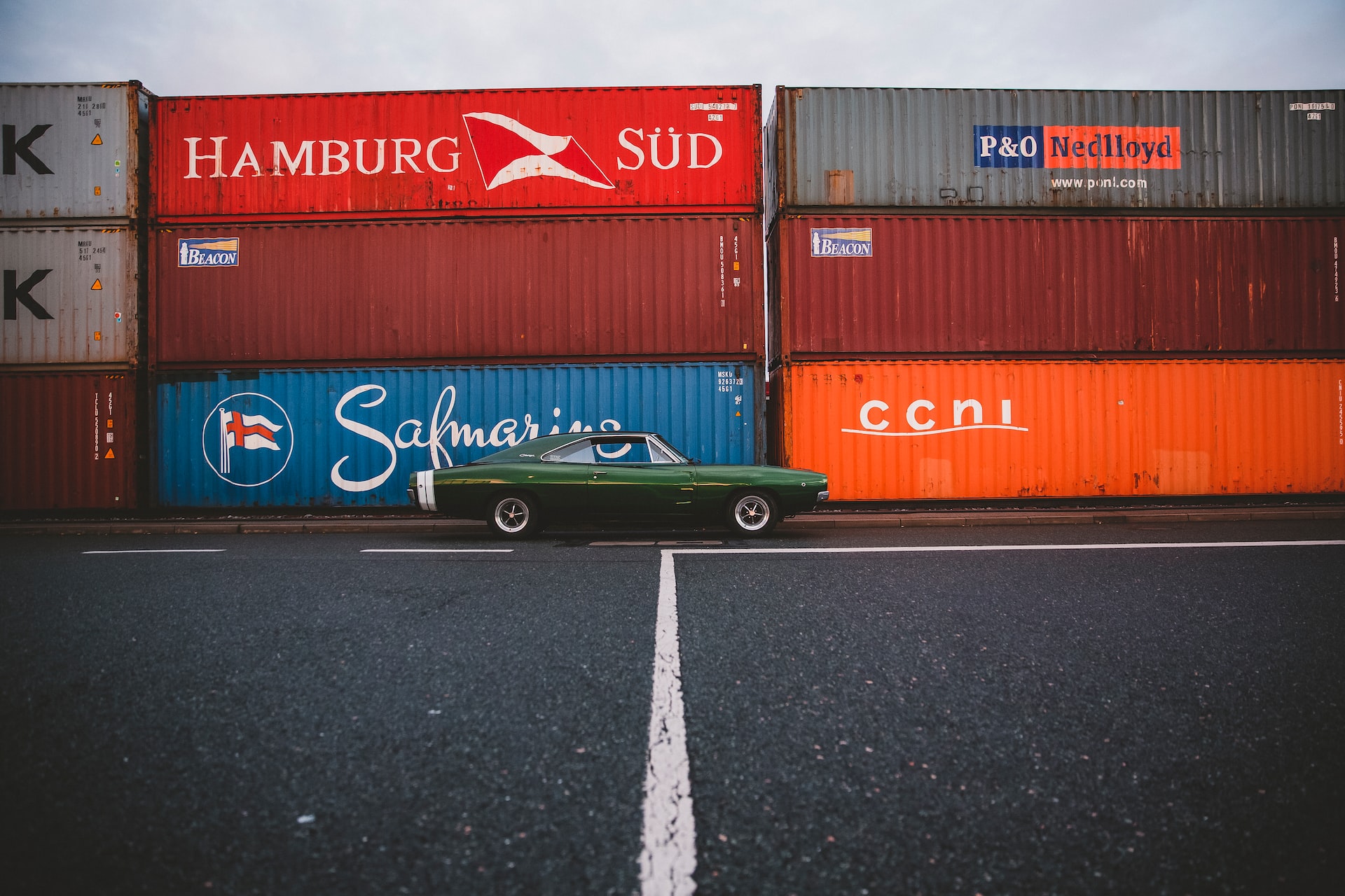 A car in front of shipping containers