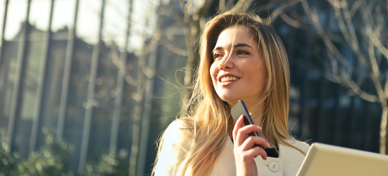 A girl smiling and holding a phone