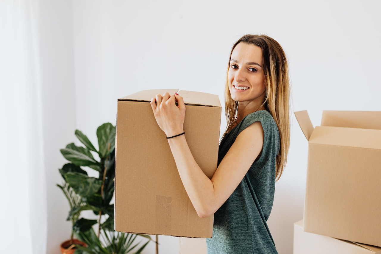 A woman smiling while holding a box