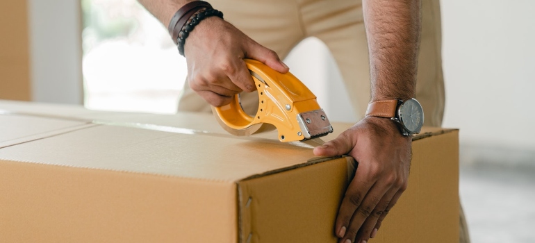 a man packing a box with items movers won't move