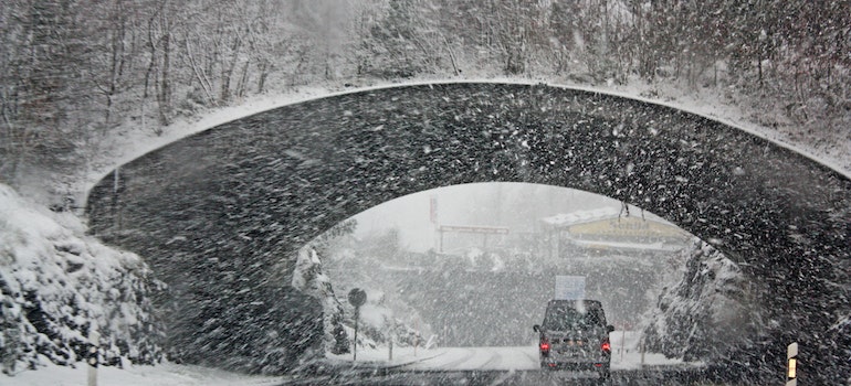 A vehicle under the bridge during snowy weather