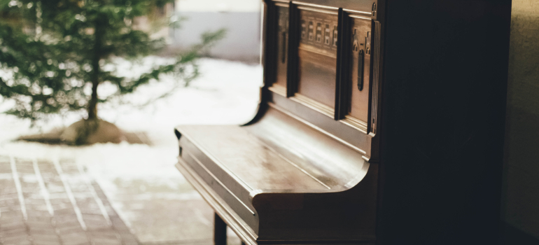 A brown wooden piano is in focus while the background is blurry.