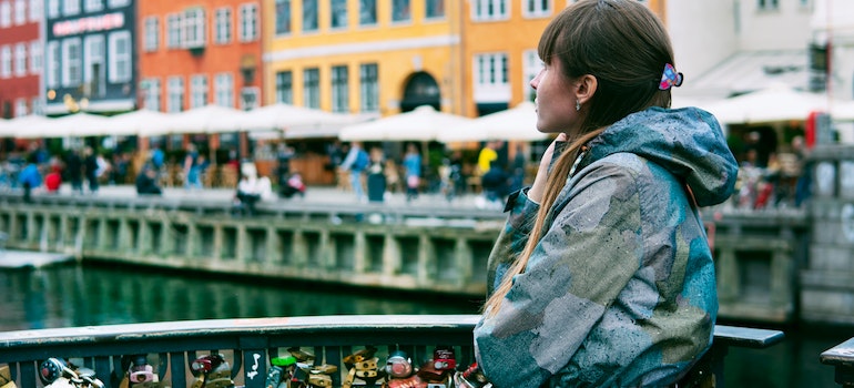 A woman standing near the water and enjoying the view