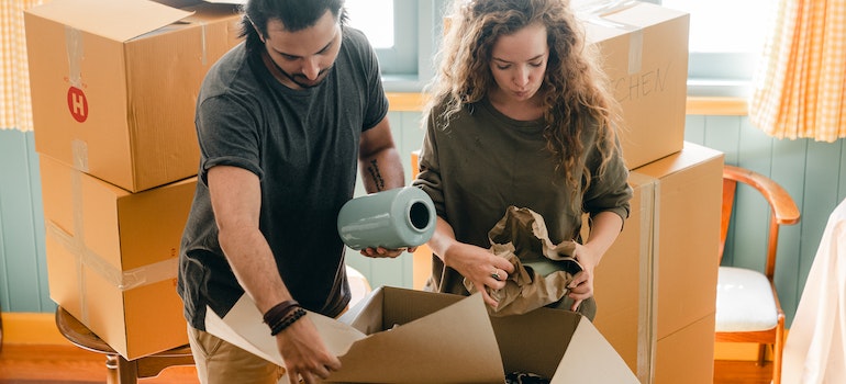 Couple packing fragile items during a DIY move
