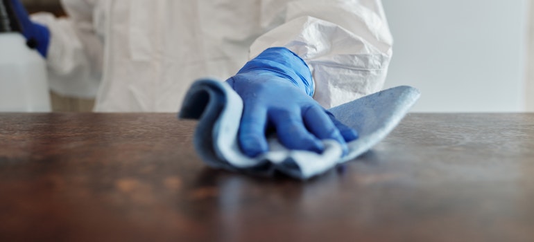 a person wearing PPE disinfecting the counters