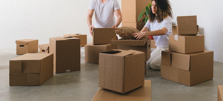 a man and a woman preparing moving boxes