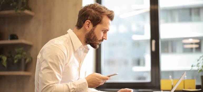 A man looking for tracking information on a laptop to track your car's shipping progress