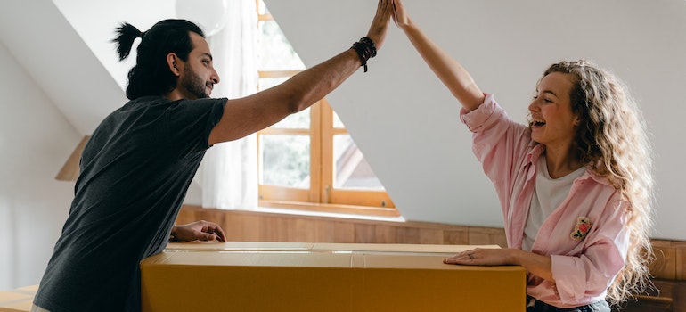 Two people giving each other high fives after moving with the help of best cross country movers Hammond