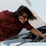 Man with long hair checking his car