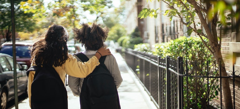 Two kids going to school on a sunny day in the city center