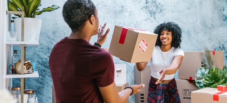 Woman Throwing Moving Box to Friend after a successful relocation