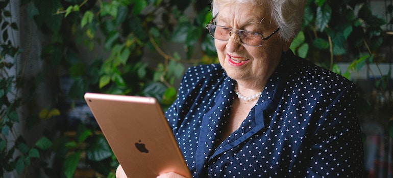 A retired person looking at a tablet in one of the places to retire in Massachusetts