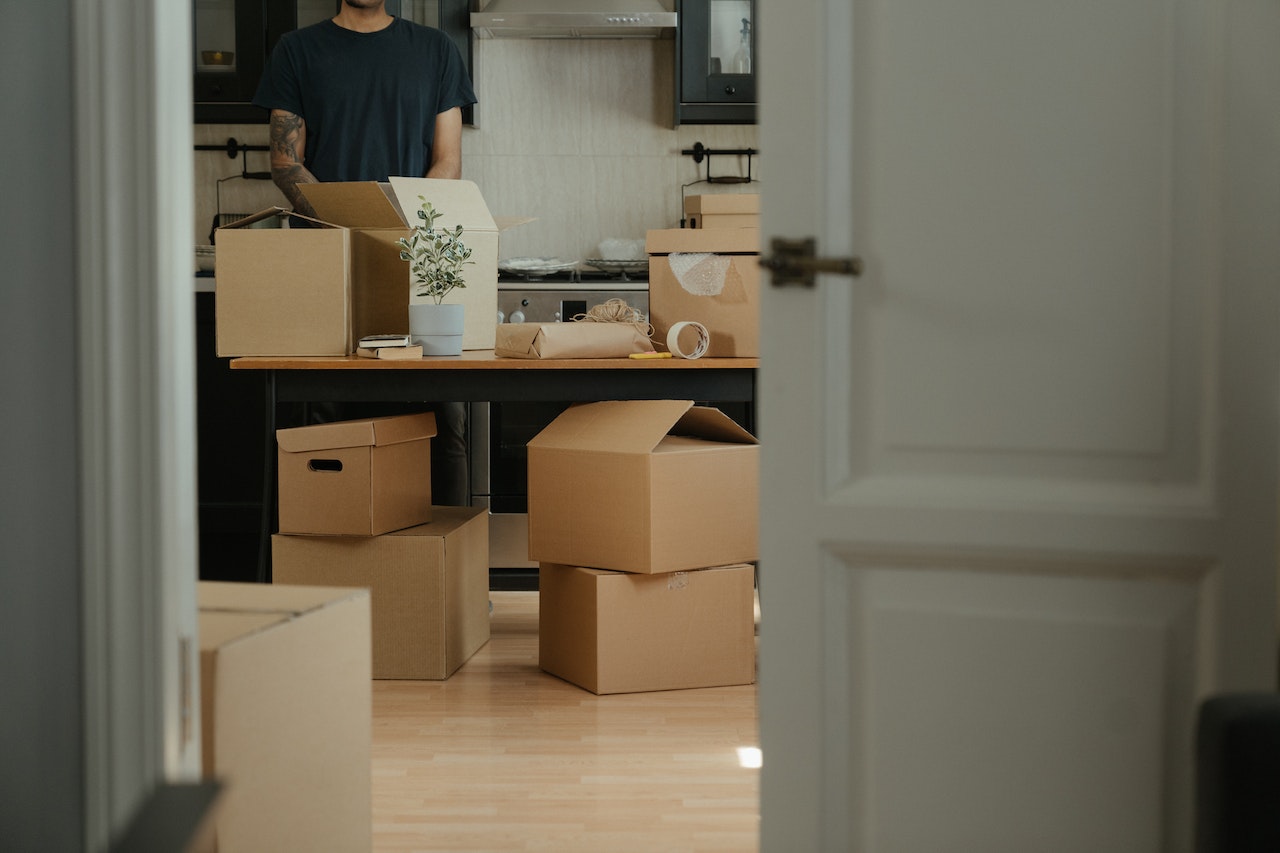 A man surrounded by moving boxes packing for a local move