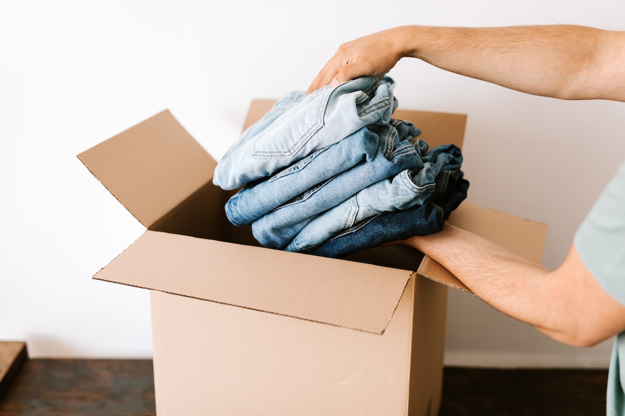 A person putting clothes in a box