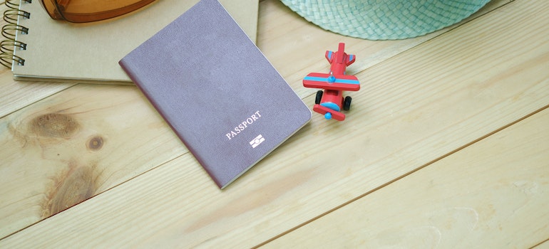 A passport on a table next to a plane toy