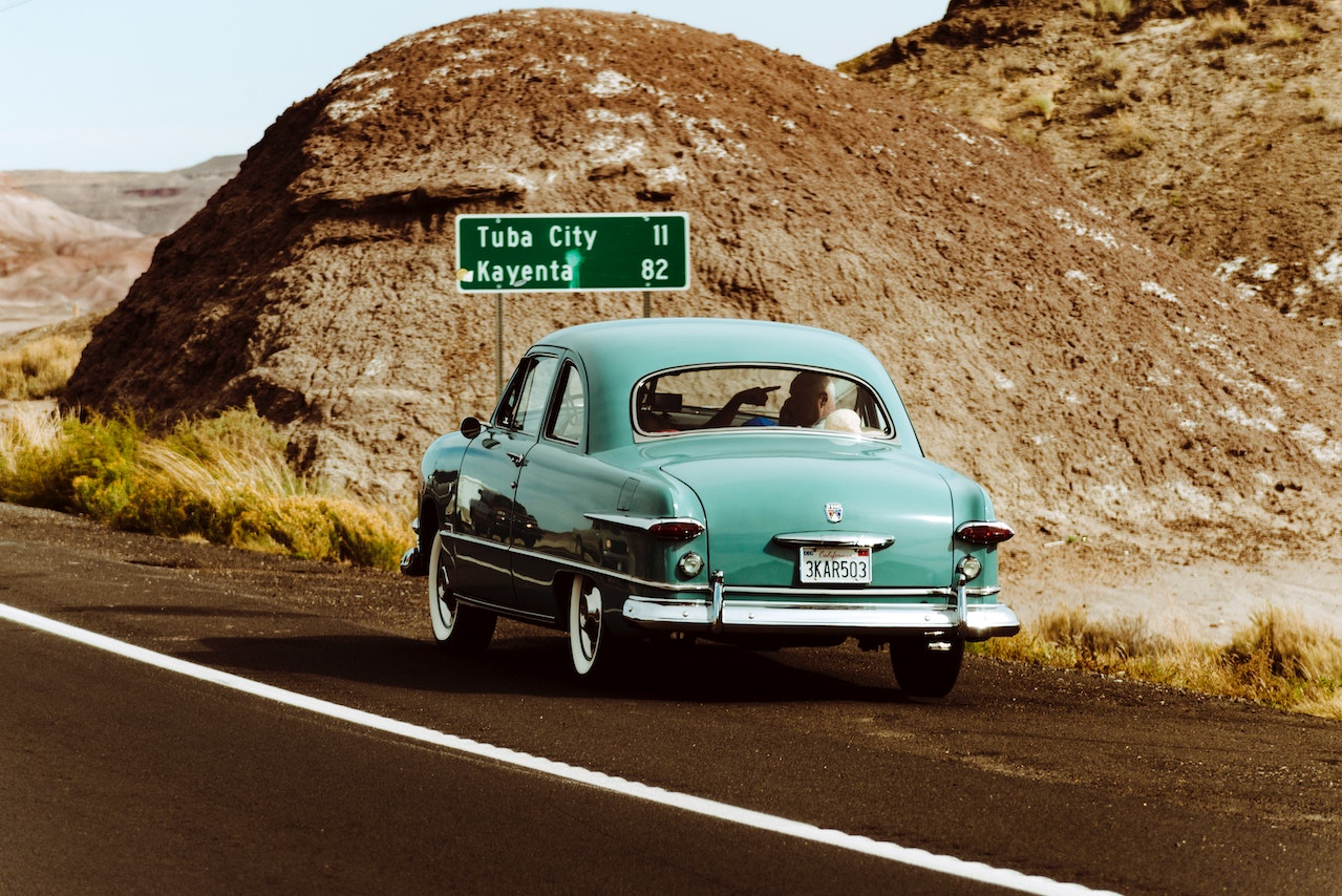 A blue old wolkswagen beetle driving on a road in Arizona to Tuba City