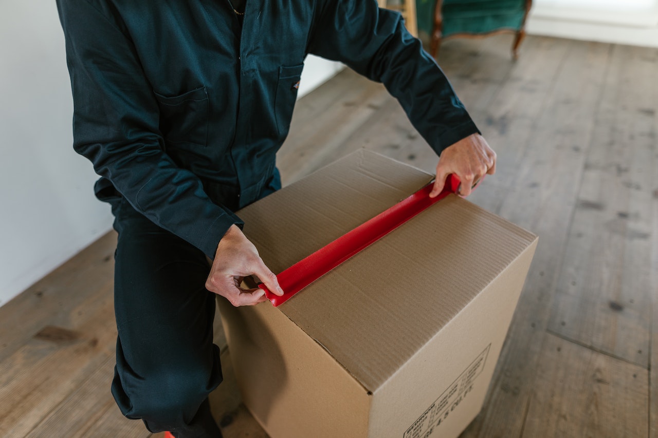 A mover form a full-service long distance moving company packing a moving box