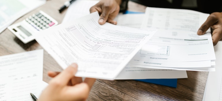 Two people looking over insurance documents before car shipping