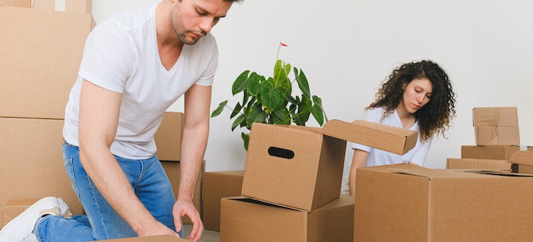 A couple packing in cardboard boxes to avoid checking for damages after a move