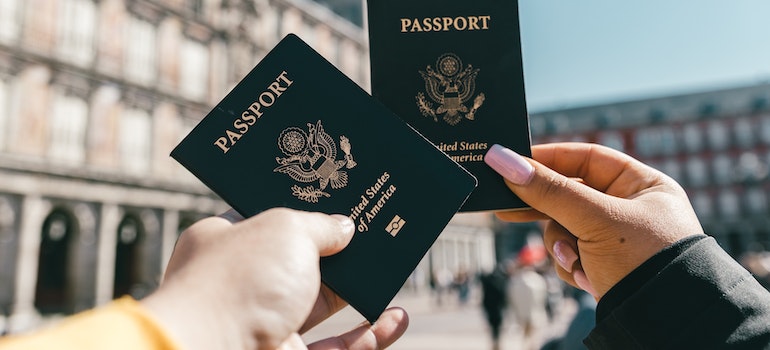 Two people holding passports of the United States of America