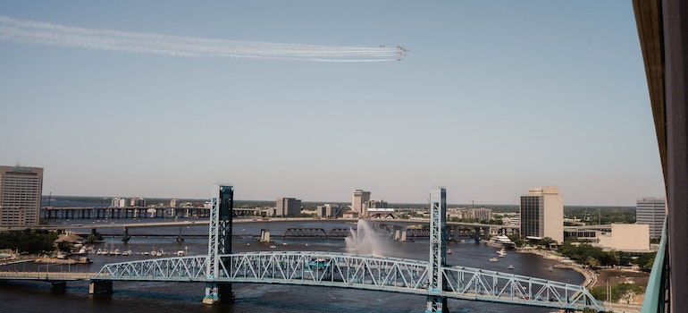 A bridge in Jacksonville with buildings in the background and planes flying over