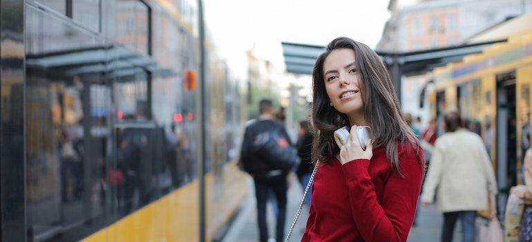 Woman in a red sweater waiting for a bus