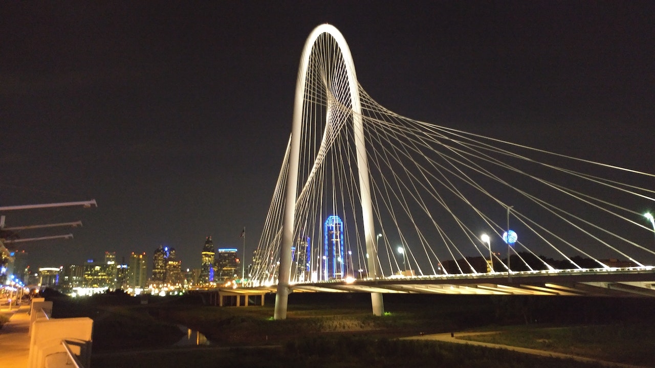 A bridge in Dallas with the surrounding buildings during the night