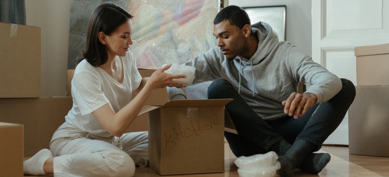A man and a woman unpacking a moving box