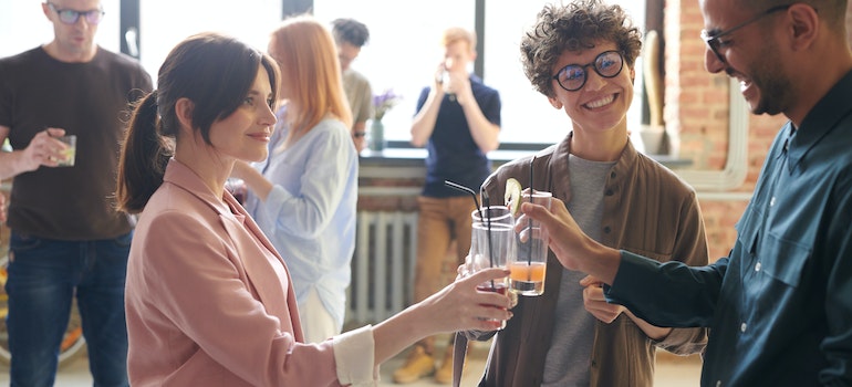 Three people drinking and talking at a house warming party
