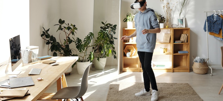 A person in their living room with a headset using virtual reality in the moving process to visualize their new home