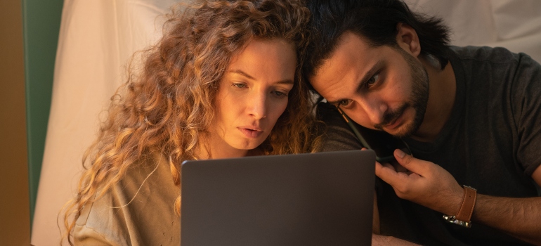 Young couple using laptop while sitting