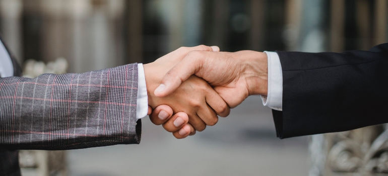 Two people shaking hands after implementing sustainable practices in the moving industry