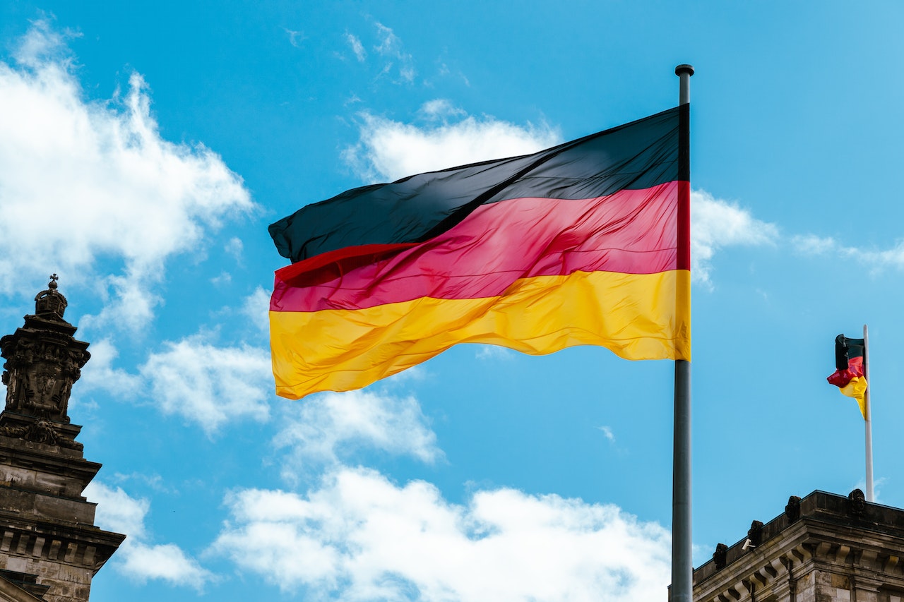 A German flag waving in the wind under the blue sky