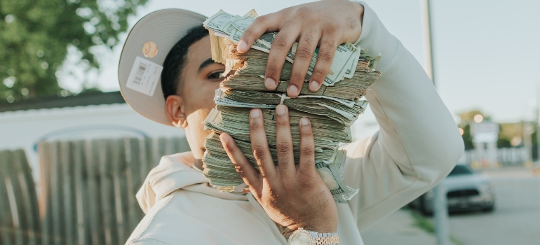 Man in white shirt with a pile of money in the hands