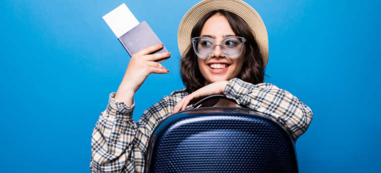 Woman holding a passport and a plane ticket before boarding a plane for moving to Paris from US