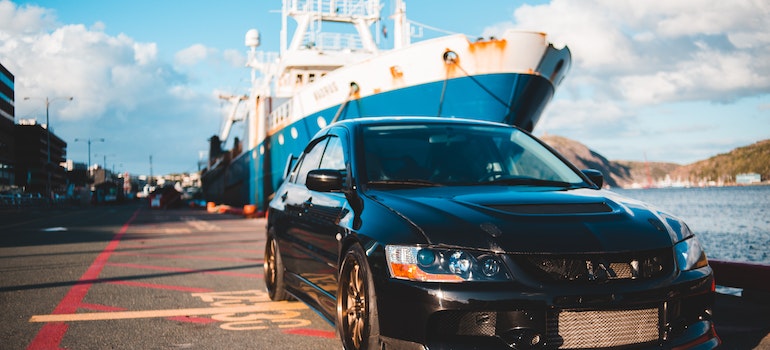 A parked car and a ship in the background