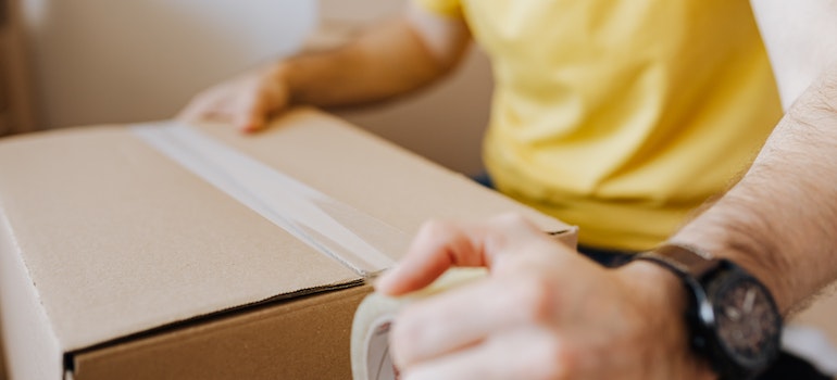 man securing a cardboard box