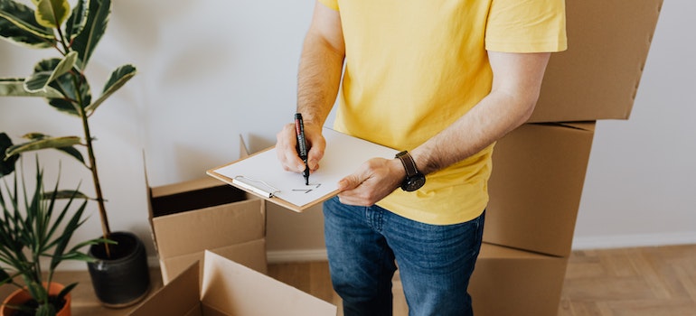 man taking notes before relocating with best cross country movers Farmington