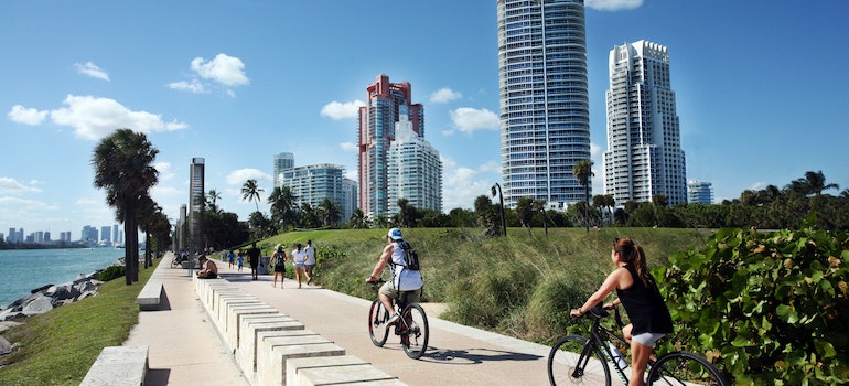 People enjoying a sunny day, walking and cycling after moving from Virginia Beach to Miami