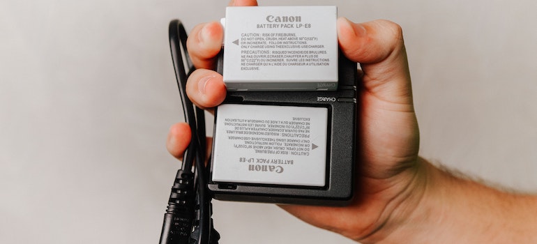 person holding a canon battery pack