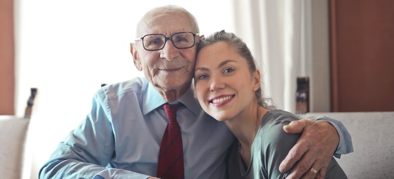 an elderly man hugging his granddaughter