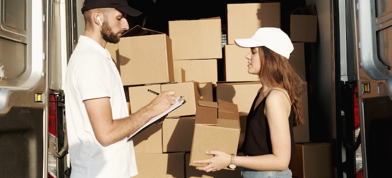 a man and a woman with a lot of boxes to deliver talking about innovative storage solutions