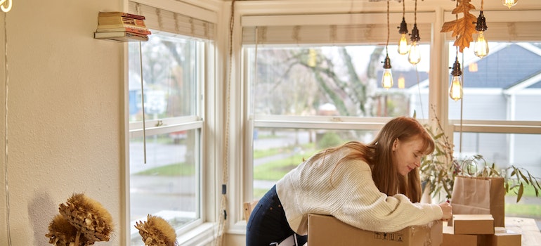 A woman with red hair packing in a kitchen