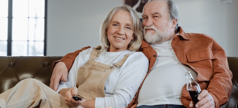 An older couple sitting on a leather couch