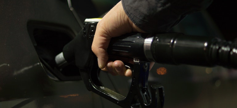 a hand putting gas in a car